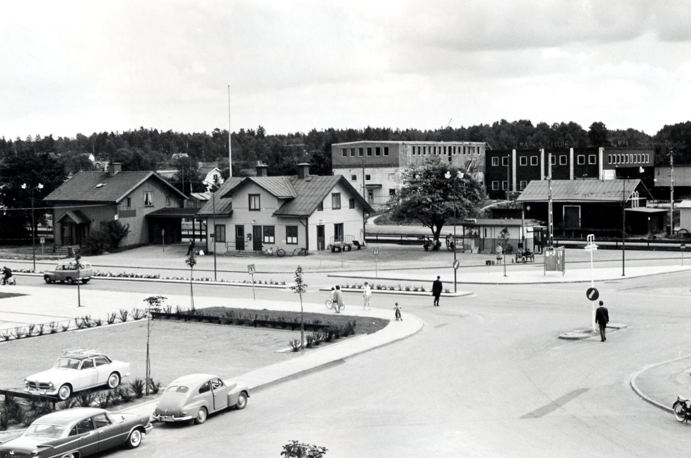 Planen mellan Vallentuna kommunalhus och Vallentuna järnvägsstation och Vallentuna järnvägshotell, Flugan till vänster. Till höger ligger Pressbyråkiosken. I bakgrunden syns en del av industriområdet med Tellus Maskins nybyggda lokaler