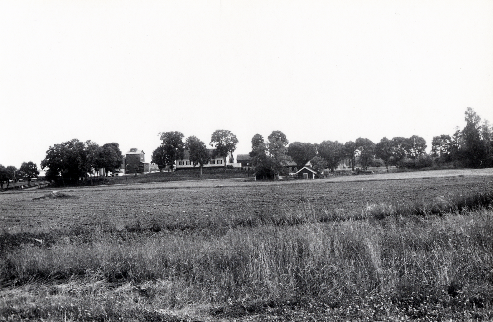 Ett nytt bostadsområde skall byggas norr om Stora Karby gård i Karby, Össeby-Garn. I juni 1985 har byggnadsarbetena inte påbörjats. I bakgrundens syns byggnader vid Stora Karby gård.  Det nya områdets hus får adress Lindgårdsvägen