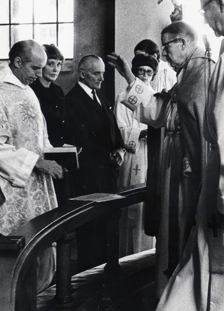 Kyrkoherdeinstallation i Vallentuna kyrka. Biskop Ingmar Ström inviger nyutnämnde kyrkoherden Per Juliusson till sitt ämbete.  T h om kyrkoherden står kyrkvärdarna Els-Marie Carlegrim och Edvin Jansson samt komminister Elisabeth Nihlén