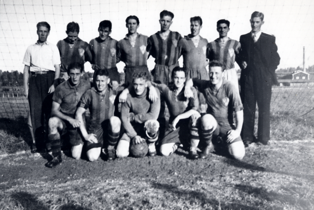 VBK, Vallentuna bollklubb, fotbollslaget på planen vid Mörby.  I bakgrunden syns Åby tegelbruk. Stående fr v Karl Holmberg, Sven Andersson Lundby, Evert Östervall, okänd anställd i Valfrid Jonssons affär, Erland 'Filip' Larsson, Lill-John 'Loket' Andersson, Sten 'Lappen' Karlsson och Bertil Tillborg.  Knästående fr v okänd säsongarbetare hos trädgårdsmästare, Harry Möller,  Folke Noacksson, Sune Brodd och Charles Östervall