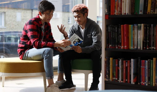 Två ungdomar i samtal på biblioteket