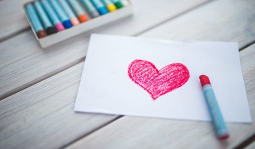 Ett målat hjärta och färgpennor