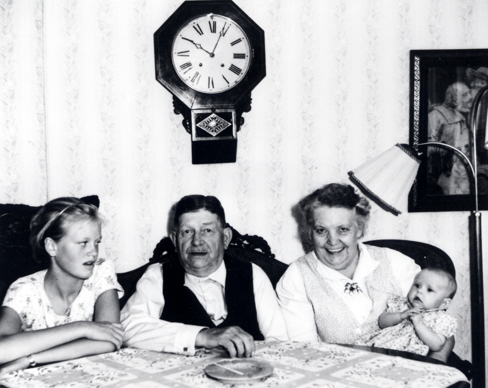 I hemmet på Kragsta gård sitter David och Ester Sundin med barnbarnen t v Marie-Louise och Anna-Karin i Esters famn. Ovanför på väggen hänger en s k amerikaklocka