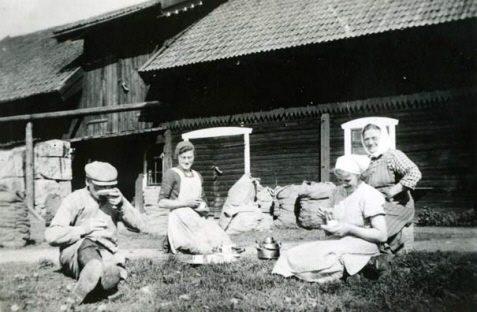 En grupp personer som sitter på gräset och dricker kaffe