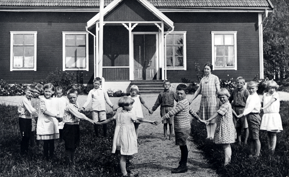 Lärarinnan Frideborg Jansson tillsammans med skolbarnen utanför Salby skola. Fr v i : Lasse Lindström Ekskogen, Stig Karlsson Ekskogens gård, Maj-Britt Lundin, Astrid Eriksson, Gustaf Lillje, Ingegerd Wiberg, Vera Lilja, Göte Svärd, Arne Gustavsson i Gropen, lärarinnan Frideborg Jansson, Maj-Britt Karlsson, Sven Svärd, Sven Nyberg och Stina Karlsson