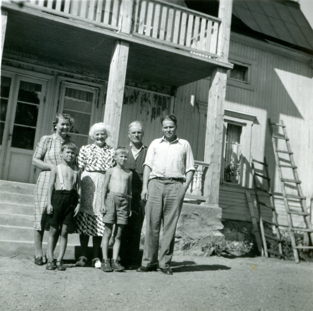 Familjen Suomalainen och familjen Ekholm utanför den nyrenoverade trappan på Ekskogens gård 1950. Från vänster Helvi och Sami Suomalainen, Inez, Timo och Manfred Ekholm samt Otso Suomalainen.
Timo och hans lillebror Sami kom till Sverige som finska krigsbarn 1944. Timo adopterades senare av ägarparet på Ekskogens gård i Kårsta, Inez och Manfred Ekholm. Läs mer i Timo Ekholms bok Krigsbarn 40.