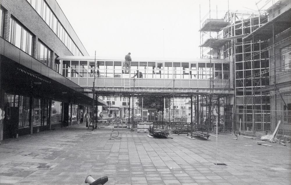 T v Tunahuset med affärer och förvaltningslokaler, t h det nya Vallentuna kommunalhus, ännu ej färdigbyggt, men inflyttningklart till julen 1987. Här byggs en förbindelsegång mellan byggnaderna