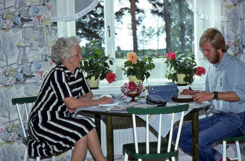 En arbetsdag med lantbrevbärare Mikael Mattsson. Lantbrevbäring i Ådalen;  Olga Nitz i Ådalen tar emot räkningar och får pensionen utbetald av lantbrevbärare Mikael Mattsson. Olgas man Anders var murarmästare. Hon flyttade senare på slutet av 1990-talet till Sommarvägen.