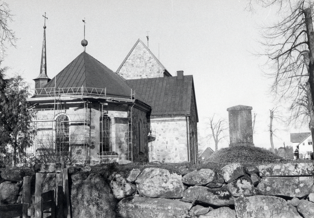 Under 1986 fick Vallentuna kyrka nytt koppartak. På bilden sett österifrån. Th på kyrkogården syns gravkullen efter Jeannette Silfverstolpe som dog endast 12 år gammal. I bakgrunden skymtar t h Pastorsexpeditionen