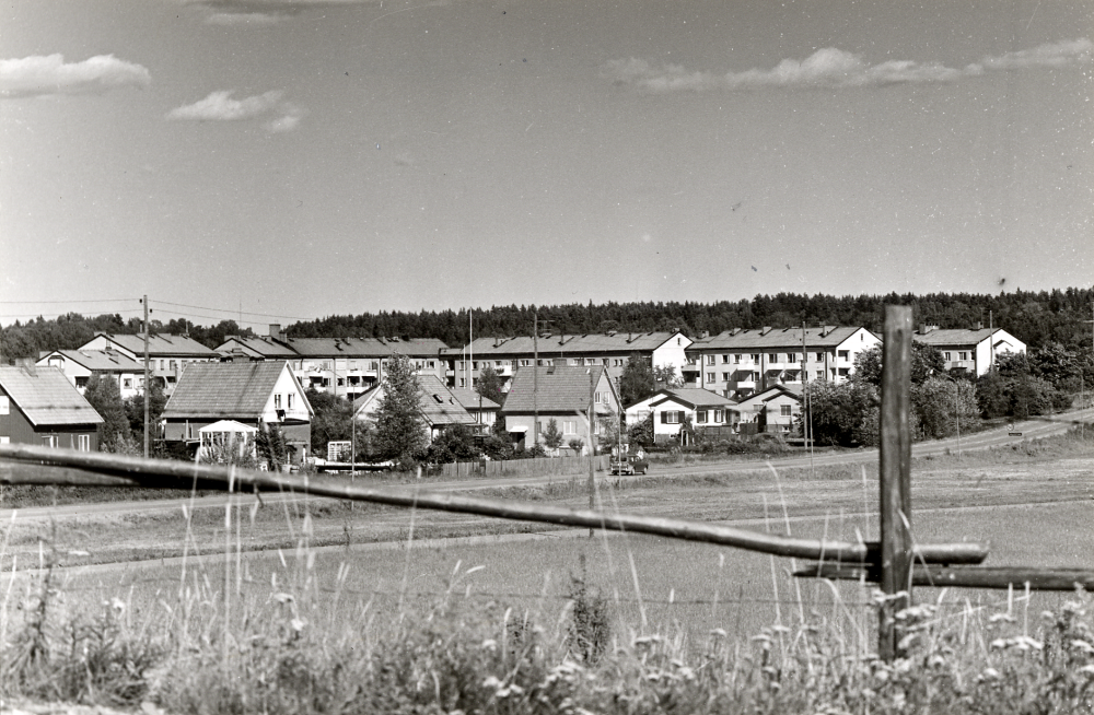 Prästgårdsgärdet  bebyggt med enfamiljshus, sett från  Kvarnbacken  I förgrunden  Väsbyvägen  I bakgrunden bakom villorna flerfamiljshus vid  Centralvägen