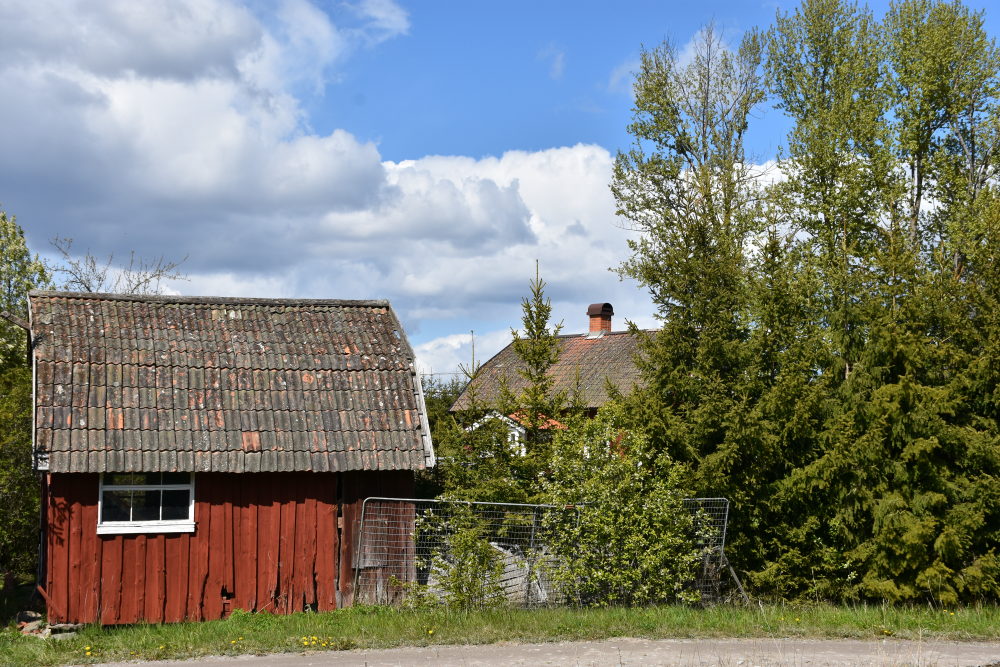 Byggnader vid Strömstorp, kallat Strömmen, i Frösunda församling. Strömstorp hörde till Lindholmens gård. Höga popplar och granar ger insynsskydd. 