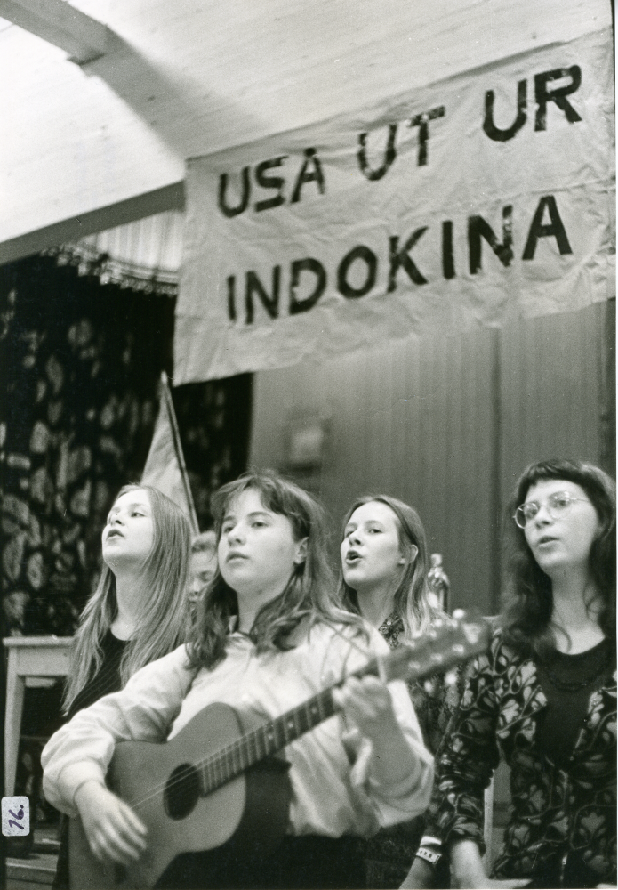 Opinionsmöte i Ekebygården med protester, sång och musik mot USA:s krig i Indokina. 
•Fotografiet ingår i bildserien ”Vardagsliv i Vallentuna kommun” av Rachael Gough-Azmier & Gunilla Blomé, Haga Studios HB.