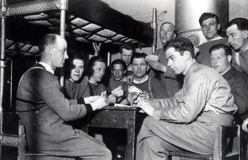 Ejnar Carlsson från Frösunda gjorde beredskapstjänst vid A1 i Stockholm. Här sitter han på luckan och spelar kort.  Ejnar Carlsson sitter på höger sida vid bordet som nr 2 i mörkare skjorta