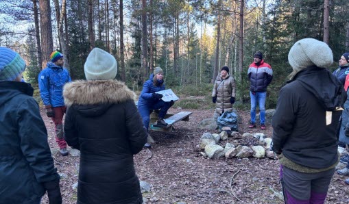 Medarbetare samlas i skogsparti för att ta del av föreläsarens vägledning.