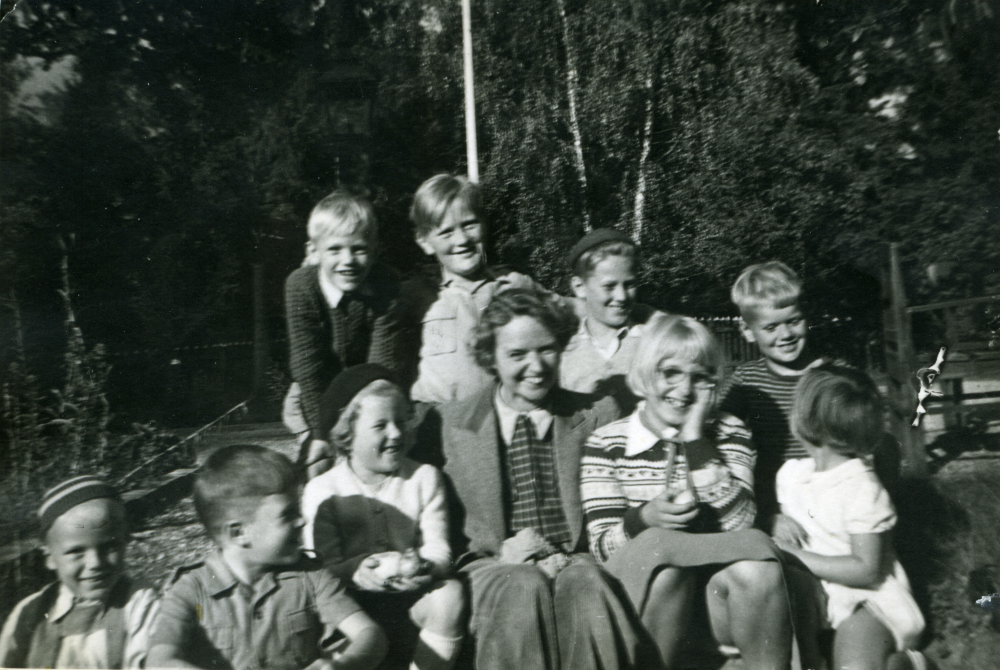 I villa Ljunggården (numera Lingsbergsvägen 10+12) bodde ”Sickan” och ”Nisse” Söderlund. Sickan var konstnär (skulptör) och bekant med den mer kända Siri Derkert. Nisse var musikhandlare och delägare i företaget ”Svala och Söderlund” i Konserthuset på Kungsgatan. De älskade barn men hade inga egna varför grannarna fick bidra med sina. Detta resulterade i att det ständigt var barn på besök hos Söderlunds. Övre raden från vänster: Jan Bornholm, Lars Bornholm, Ulf Sundborg, Urban Bornholm.  Mellan raden: Gunilla Sundborg, ”Sickan” Söderlund, Birgitta Johansson, Eva Bornholm. Nedre raden: Leif Olsén?, Arne Nordgren. Foto och uppgifter från Lars Bornholm 2016.