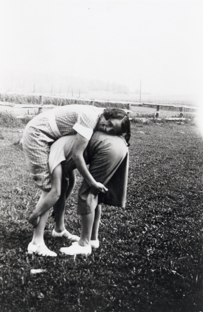 Karin Helgöstam och Dagmar Thunberg gör ett försök att dansa björndansen på Helgö gård.  På kortet står " En blygsam början på björndansen"