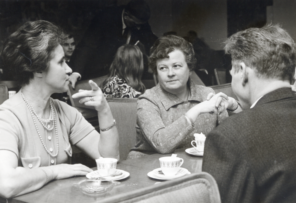 Kaffepaus i  kommunalfullmäktiges sammanträde  i  sessionssalen  i Gamla kommunalhuset.  Fr v  Hulda Lundgren  och  Lene Aae-Johansson.  Med ryggen mot kameran troligen Knut Johansson