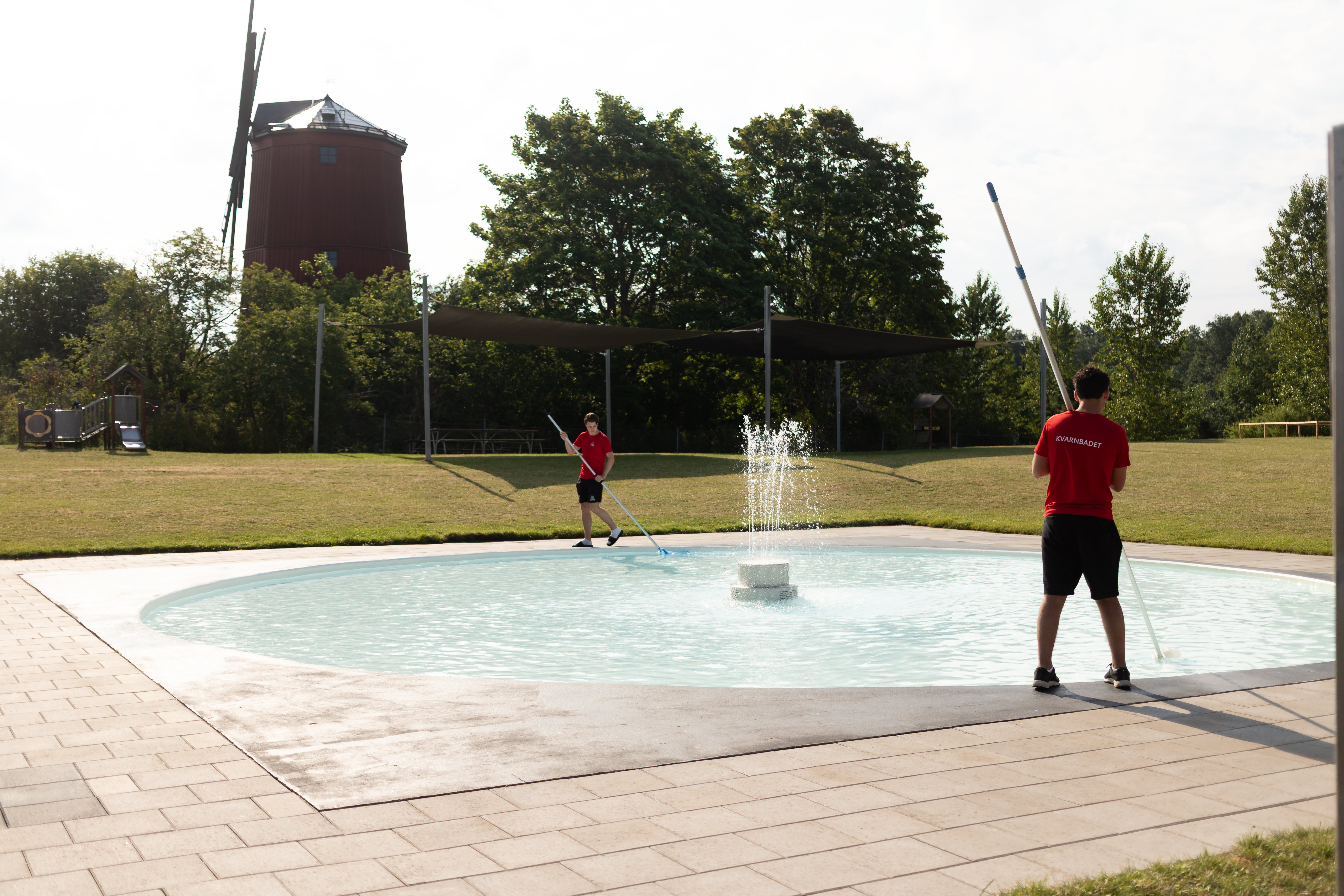Sommarjobbare rengör pool på Kvarnbadet