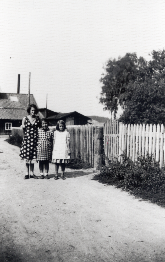Granby kvarn och såg i Orkesta.  På vägen utanför mjölnarbostaden står fr v Margareta Öhman, Britta Hedlund (Bergfors) och klasskamraten Aina Andersson.  I bakgrunden syns kvarnen och sågen