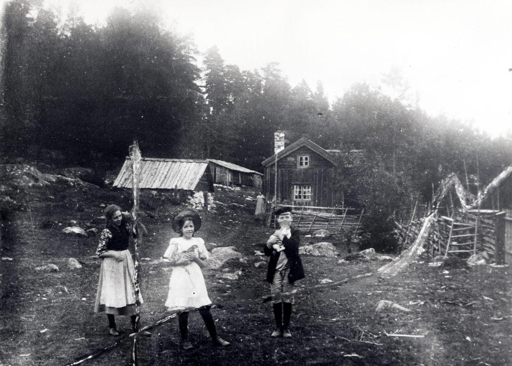 Syskonen Widén, fr v Agnes, Judit och Axel Martin, framför Sjöberg i Frösunda.  Invid husknuten står mamma Maria och ser på.  Fotograf är fadern Axel Widén, foto ca 1912-15, något av de fem åren familjen var bosatt på torpet, som hörde till Solsta, fastighetsbeteckning Solsta 1:4