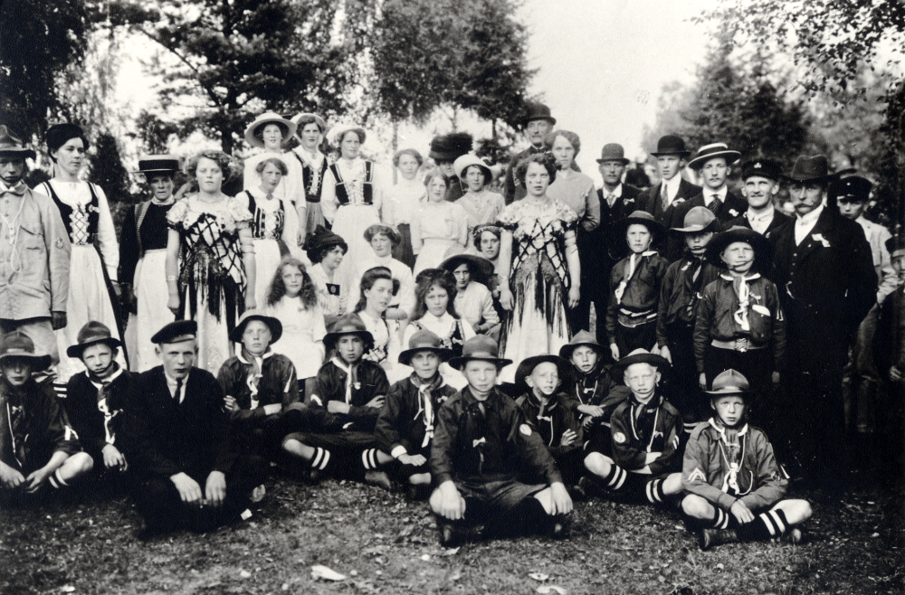 Vallentuna skytteförening  har  sommarfest  vid  Åbyholm   Vallentuna scoutkår  deltog som funktionärer. Mannen t h med mustasch är banmästare Henning Henningsson  hans hustru barnmorskan  Berna  står i stråhatt t v, framför henne står  Edit Lindström  blivande lärarinna i Vallentuna. Närmast Henningsson står  t v Karl Bornholm,  trogen medlem i Vallentuna hembygdskör.  Bland de sittande scouterna sitter  Sixten Palmblad  längst t h, son till handlaren Gustav Palmblad och gift med Mimmi, dotter till K P Gustafsson. Sixten dog 1989.