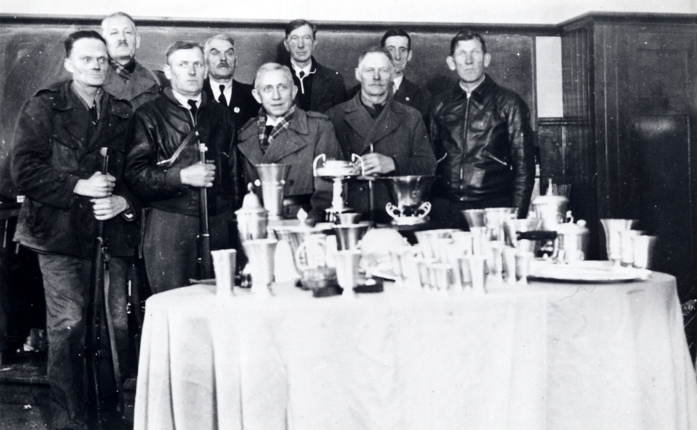 Össeby-Garns skytteförening  firar 40-årsjubileum.  Fr v  Johan Andersson,  Gustav Nilsson,  Axel Fransson, Edvard Karlsson,  kyrkoherde  Olle Mattsson  (prisutdelare?),  Fritz Gustavsson, Carl Lillje   Helge Eriksson  och  Alfred Schröder