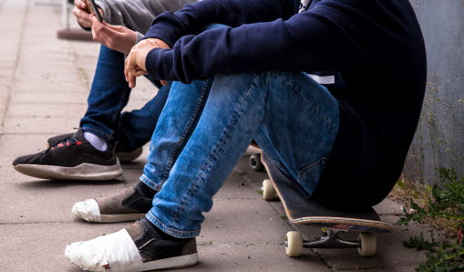 Ungdomar sitter på skatboards.