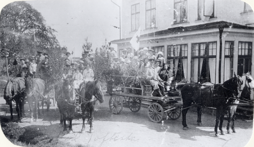 Skolbarnen från Stångberga skola åker omkring på herrgårdarna och samlar ihop pengar till Röda korset.  Morsta gård ordnade med 2 skjutsar. Barnen sitter på flaken.  Här har man gjort ett uppehåll på Toftesta gård.  Lärarinnan Viola Åslev tjänstgjorde ca 1920 i Stångberga skola.