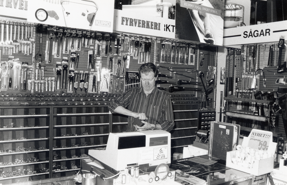 Interiör från Vallentuna järnhandel på Centralvägen.  I butikens kassa står Ragge, Ragnar Sundkvist - väl förtrogen med järnhandelns sortiment
