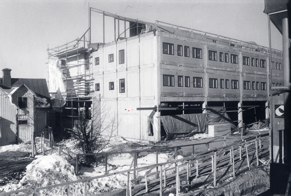 Vallentuna bibliotek  byggs. Alla våningarna är klara och taket läggs på. T v syns  Kära barns affär  och t h skymtar  Domus  just färdigbyggda varuhus. Biblioteks- och förvaltninghusets namn blev  Tärningen  döpt efter det tärningsfragment som hittades vid utgrävning på området