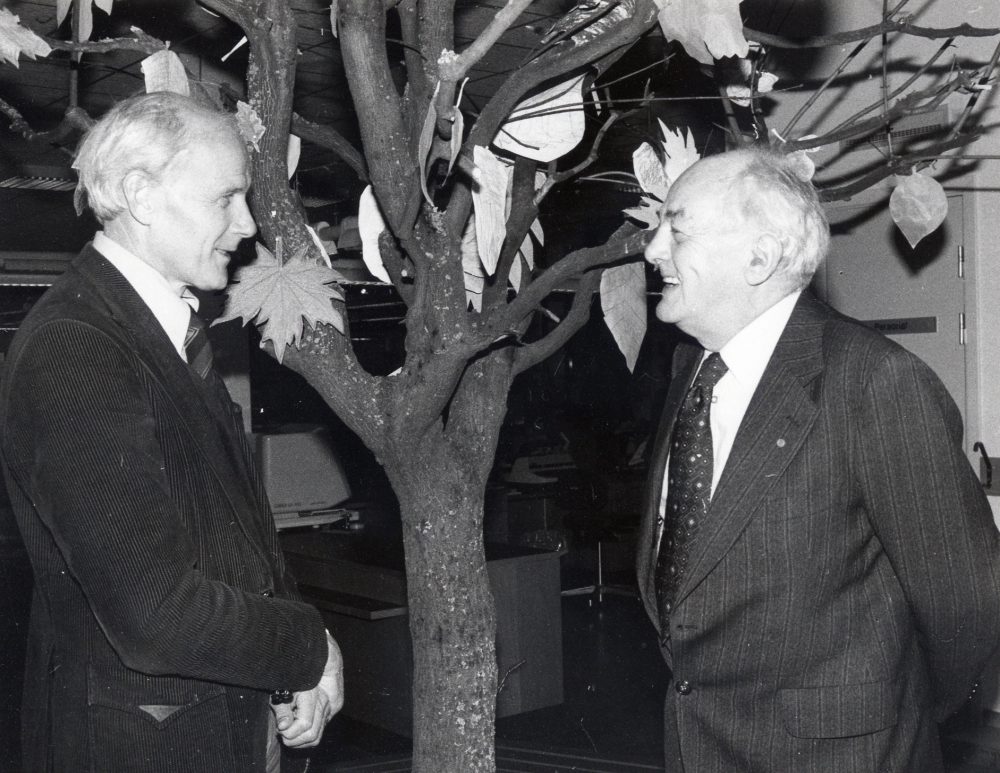 Gunnar Käller  t v och  Martin Linder  i samspråk under trädet på barnavdelningen i  Vallentuna bibliotek   Martin läste en berättelse om Julia Fredlund, lärarinna i Vallentuna och bl a initiativtagare till varmbadet i Vita skolan i Hjälmsta. En programpunkt under programdagarna  Boken firar 500-års jubileum 1483-1983