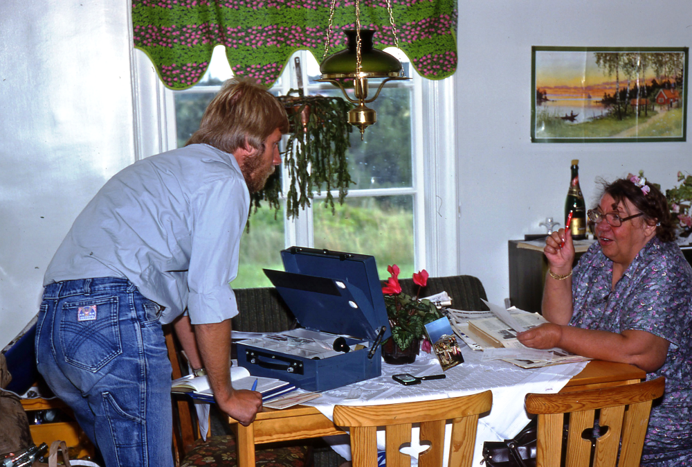 En arbetsdag med lantbrevbärare Mikael Mattson. Lantbrevbäring i Örsta;  Mikael Mattsson gör en pensionsutbetalning till Karin Jansson i hennes kök i Örsta.  Örsta och Angarnssjöängen skymtar utanför fönstret. 