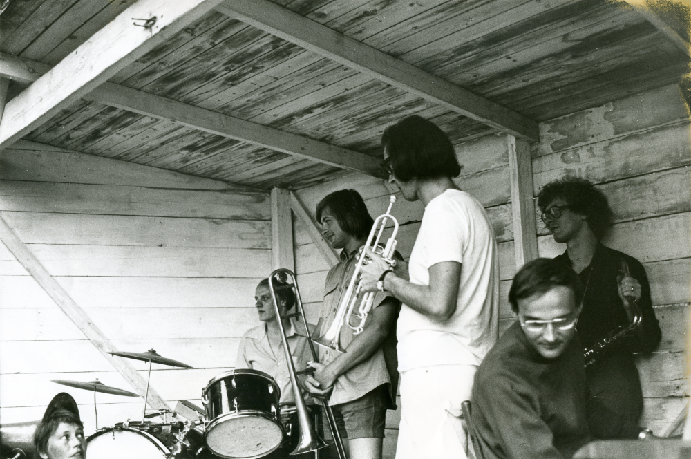 Festligheter vid Frösunda festplats i juli 1973. Bandet spelar New Orleans-musik att dansa till. Konstnären Ulf Gripenholm på trummor, namn på övriga musikanter är okänt men ska enligt uppgift var hans "kollegor".
•Fotografiet ingår i bildserien ”Vardagsliv i Vallentuna kommun” av Rachael Gough-Azmier & Gunilla Blomé, Haga Studios HB.