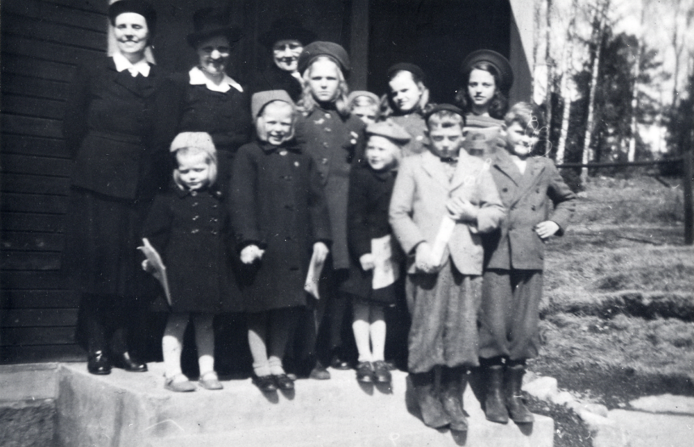 Söndagsskola i Sursta kapell, Filadelfiakapellet, i västra Vallentuna. Tanterna fr v Hilda Johansson, Lilly Andersson och Elin Mattsson. Barnen fr v i bakre raden Birgitta Fröman, Elisabet Fröman, Margit Hedlund, Birgit Jansson (knappt synlig), Ingegerd Evén och Barbro Jansson. Främre raden fr v Lillemor Eriksson, Ola Hedlund och Tore Hedlund