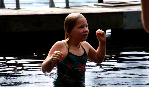 Barn som badar i en sjö