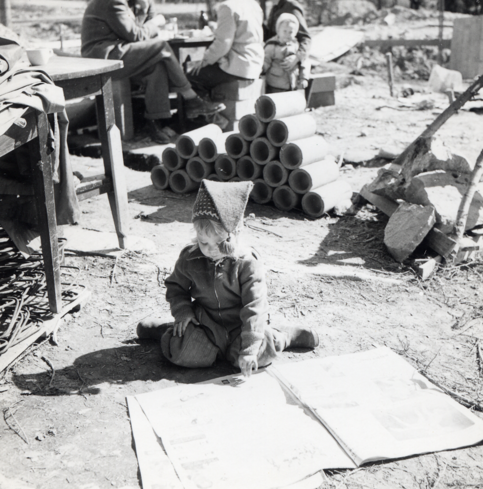 Tove Gustafson läser medan föräldrarna Ulla och Bengt Gustafson bygger familjens hus på Norrängsvägen 5