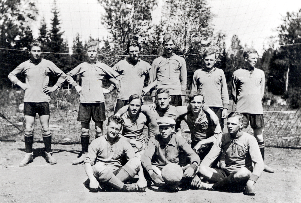 Frösunda IF på bortamatch i Hallstavik.  I bakre raden fr v Ragnar Wredh, Uno Uddenberg, Gösta Jansson,  "Valla" ?, Erik Gustafsson Stensborg Kårsta, Erik Sandgren Kårsta.  Knästående fr v Werner Gustavsson, Ingvar Gustavsson och Holger Céwe.  Sittande fr v Hjalle Asplund, Fredrik Johansson och Gösta Johansson.  Bröderna Johansson antog senare släktnamnet Helgöstam.