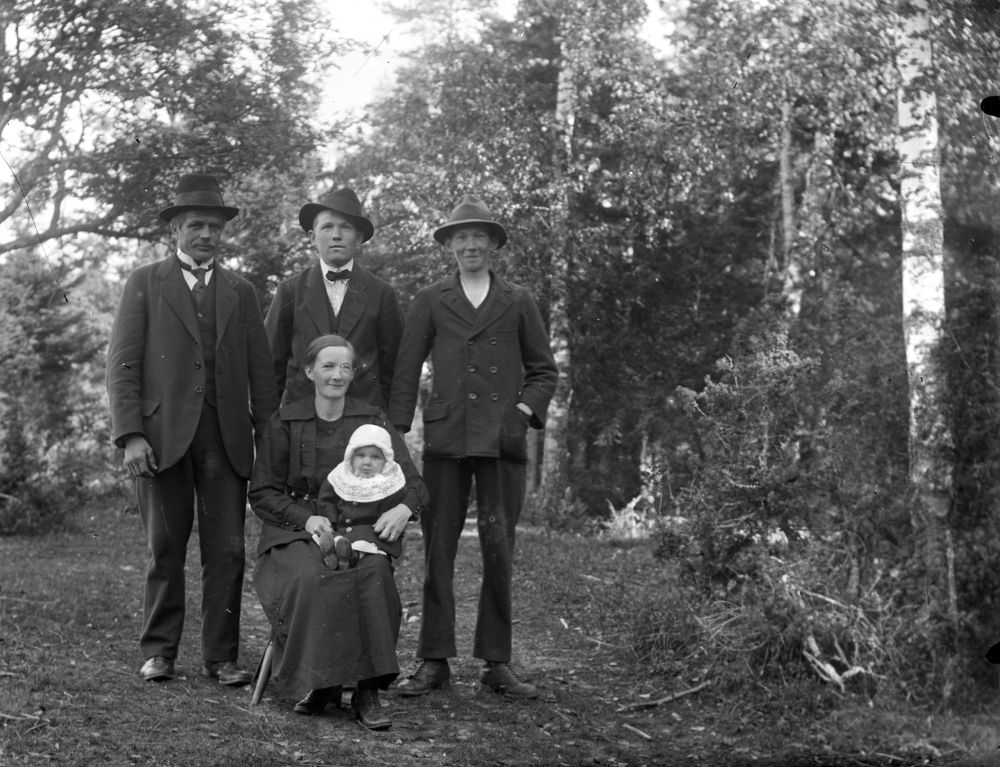 Från vänster Karl Andersson (gift med Tilda), Sven Andersson, Knut Andersson (Sven och Knut är bröder) och sittande Tilda Andersson (född Andersson) med dottern Karin (född 1920). Tilda (Matilda) är syster till Sven och Knut. Bilden är tagen vår/sommar 1922. Fotograf: Algot Laurell? Stenberg?
