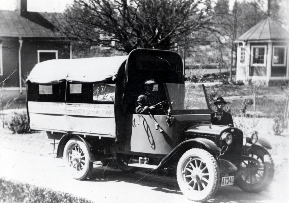 En lastbil i Kårsta.  På flaket står ..Herrängen Segeltorp. Plats och anledning okänd.  Bilen har endast sufflett, ingen ordentlig förarhytt. Signalhorn med gummituta sitter på höger sida, ingen dörr finns på den sidan.