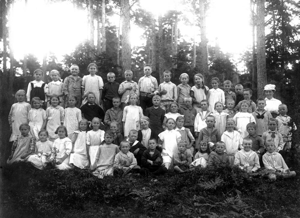 Lärarinnan Hanna Krantz tillsammans med skolbarnen, troligtvis vid Hjälmsta skola. 

