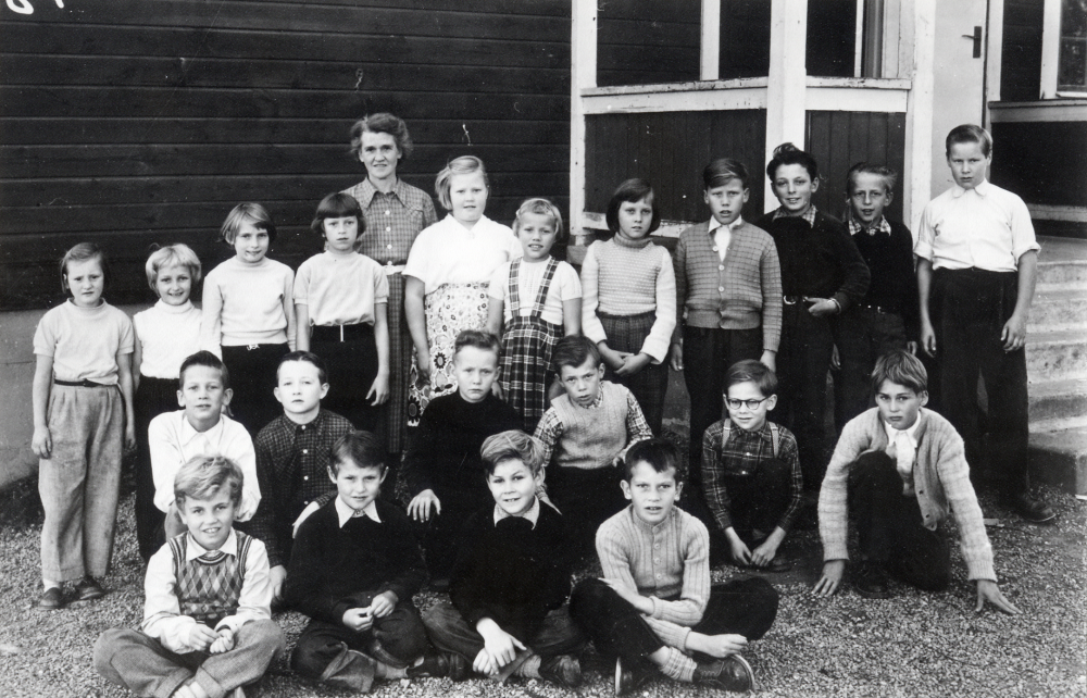 Lärarinnan Signe Andersson tillsammans med skolbarnen utanför Åvasta skola. Övre raden fr v Elsa Eriksson, Gunilla österberg, Inger Lundin, Ulla Stolpe, Ulla Öhman, Vanja Pettersson, Ann-Marie Jansson, Torbjörn Pettersson, Sune Lindberg, okänd och Kjell Wahlström. Mellanraden fr v Rickard Sjöstrand, Tommy Hedlund, Åke Enström, Sune Eriksson, Lars Andersson och Örjan Öberg. Nedersta raden fr v Ulf Dahlsten, Gunnar Pettersson, Lennart Lund och Bo Zackariasson