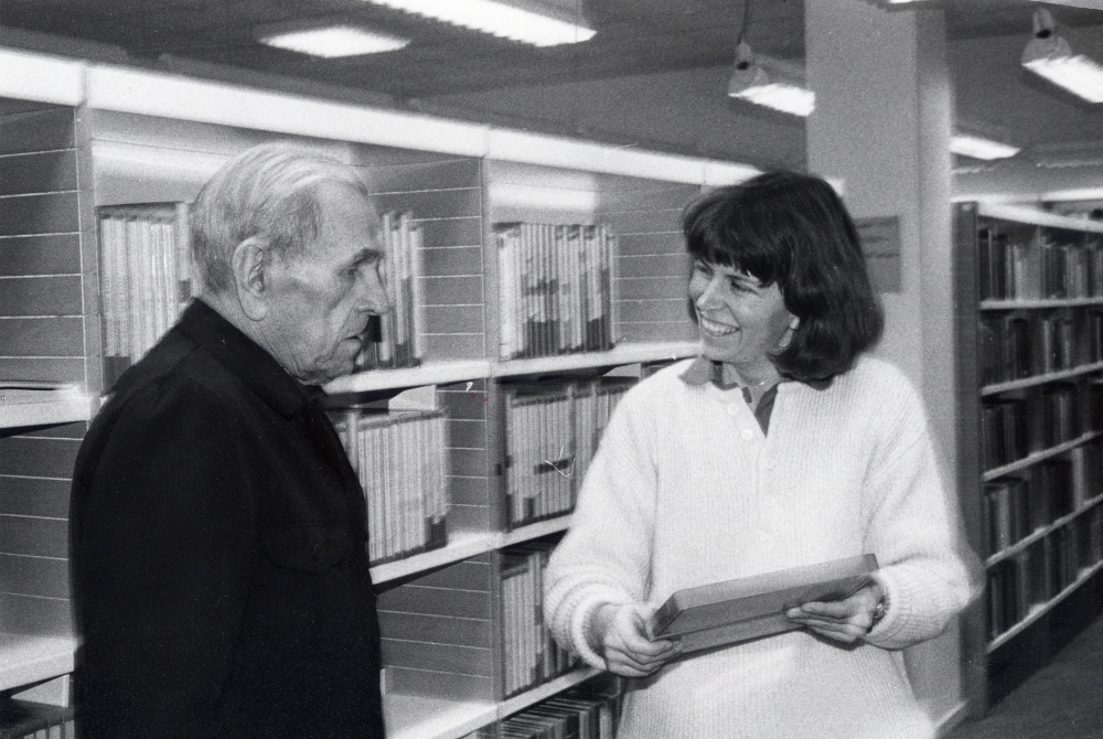 Lena Lundgren hjälper John Ängaryd att välja en bok från talbokshyllan i Vallentuna bibliotek