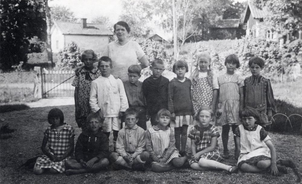 Lärarinnan  Ida Solem  tillsammans med skolbarnen utanför  Angarns kyrkskola
