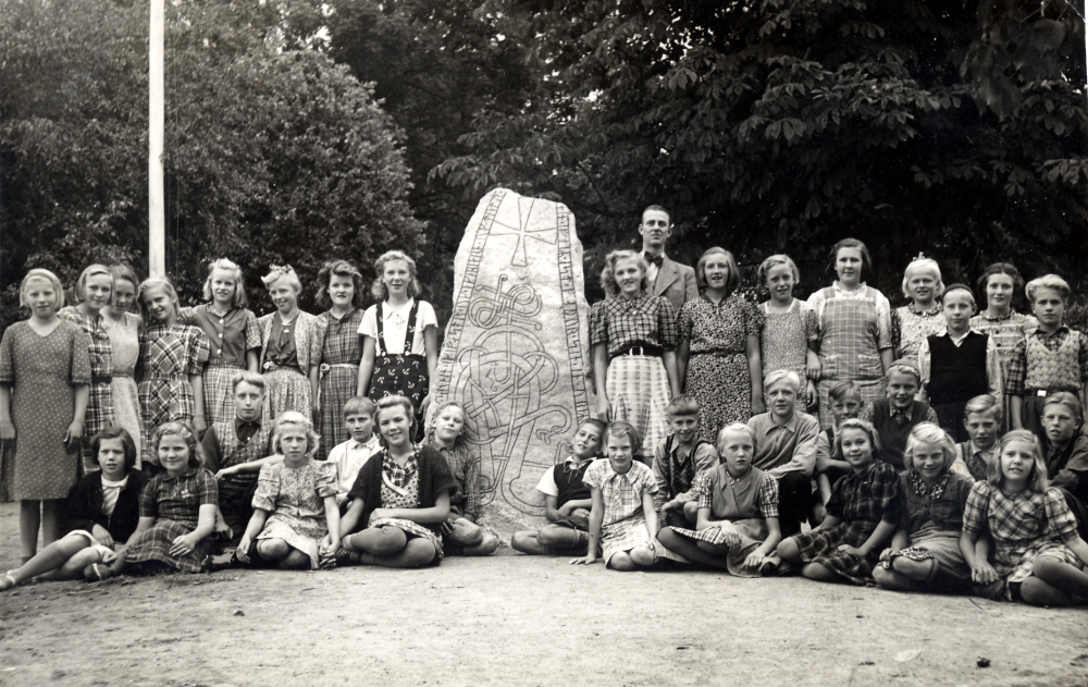 Läraren Gösta Sahlin med skolbarnen i klasserna 5 och 6 i Össeby-Garns kyrkskola. I bakre raden fr v står Maj-Lis Andersson,  Anni-Britt Degling, Anna Greta Lindman, Beatrice Hoffman, Ulla Alstermark, Berit Johansson, Gun Lindholm, Eva Jonsson (Hessler), läraren Gösta Sahlin, Sally Johansson, Kerstin Karlsson, Gunvor Johansson,  Dagmar Fogelström, Ulla Gustavsson, Gunnar Pettersson, Gun Nordström (Eriksson) och Conny Almén.  I nedre raden från väster Ansy Åkerblom, Margit Karlsson, Hans Lindblom, Alva Henriksson, (Karlsson), Lennart Johansson, Irma Gustavsson (Eriksson), Kurt Degling, Gunnar Johansson, Alma Johansson, Rune Eklund, Linnea Johansson, Uno Andersson, Siv Kraemer (Gustavsson), Börje Lindman, Roland Höglund, Maj-Britt Medin, (Sundgren) Bertil Bergkvist, Maj-Britt Hoffman och Karl-Erik Karlsson