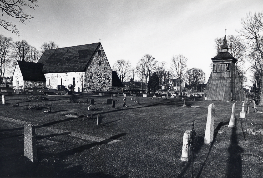 Frösunda kyrka sedd från sydoft med klockstapel t h. Mellan kyrkan och klockstapeln syns Frösunda prästgård