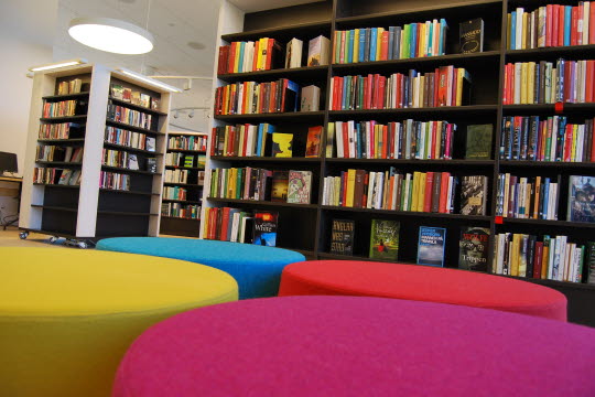Sittpuffar och bokhylllor fyllda med böcker i biblioteket, Vallentuna Kutlurhus