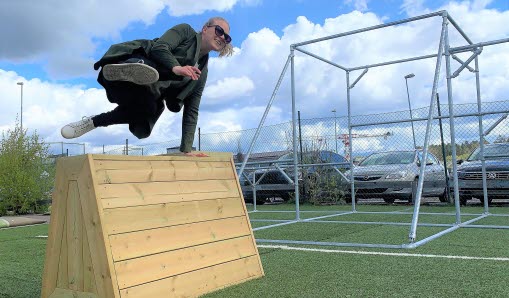 Tjej som hoppar över hinder i parkourbana