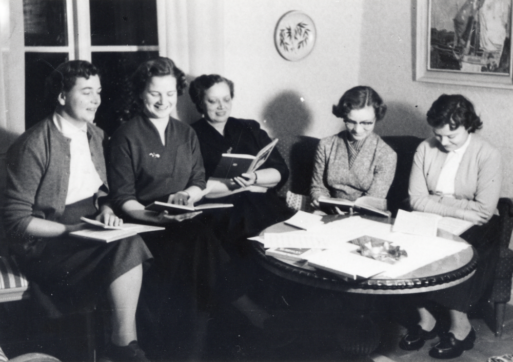 Delar av Vada kyrkokör övar i lärarbostaden i Vada skola. Läraren Stig Karlsson och hans hustru SigBritt var körens ledare.  Runt bordet sitter fr v Anna-Lisa Ländin, Ulla Wester, Ester Ericsson, Gunvor Ericsson (gift Lundberg) och Gun-Britt Frölin(gift Lövdahl).  Förmodligen är Stig Karlsson fotograf