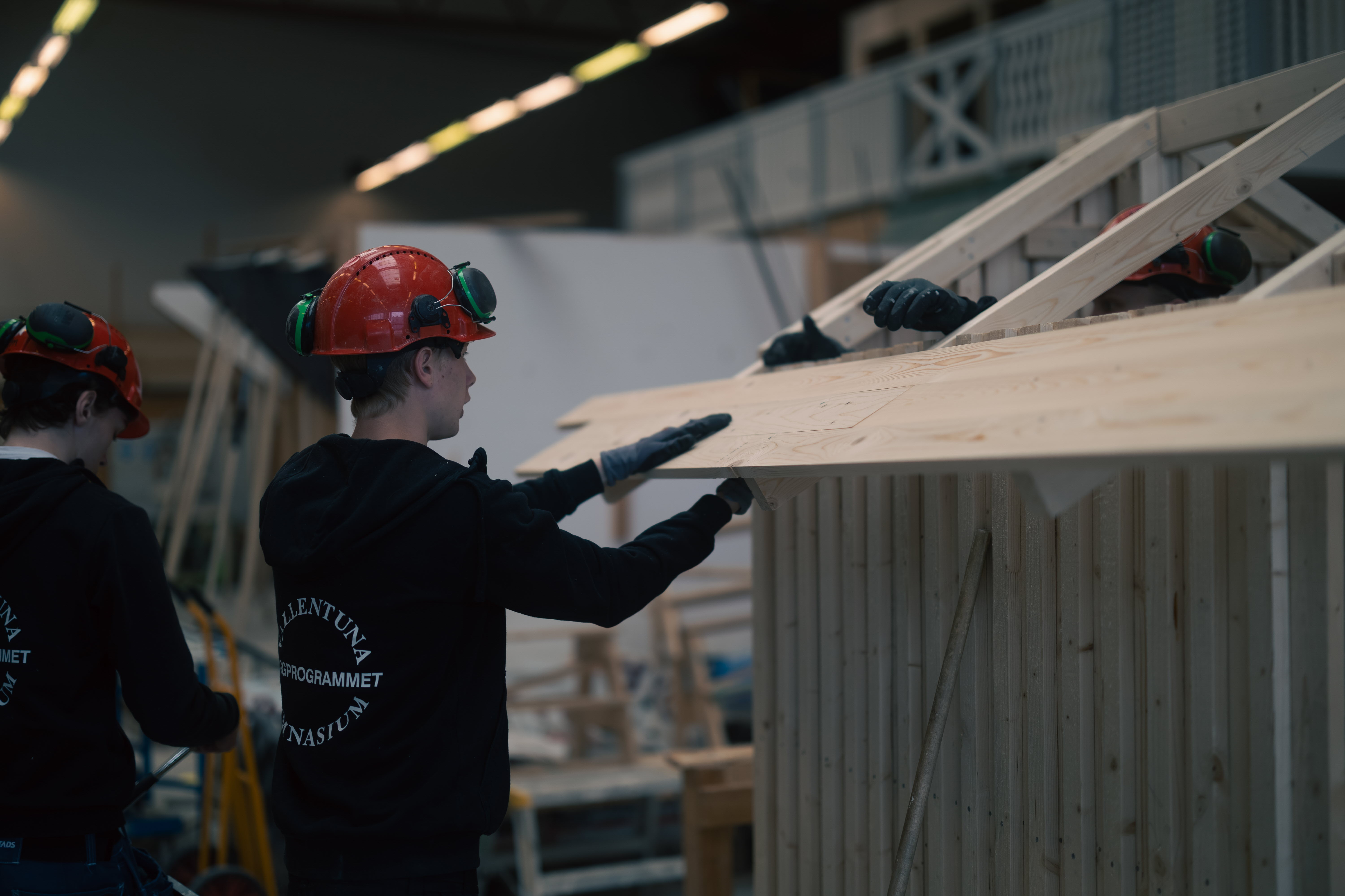 Elev arbetar med brädor till ett tak för ett modulhus.