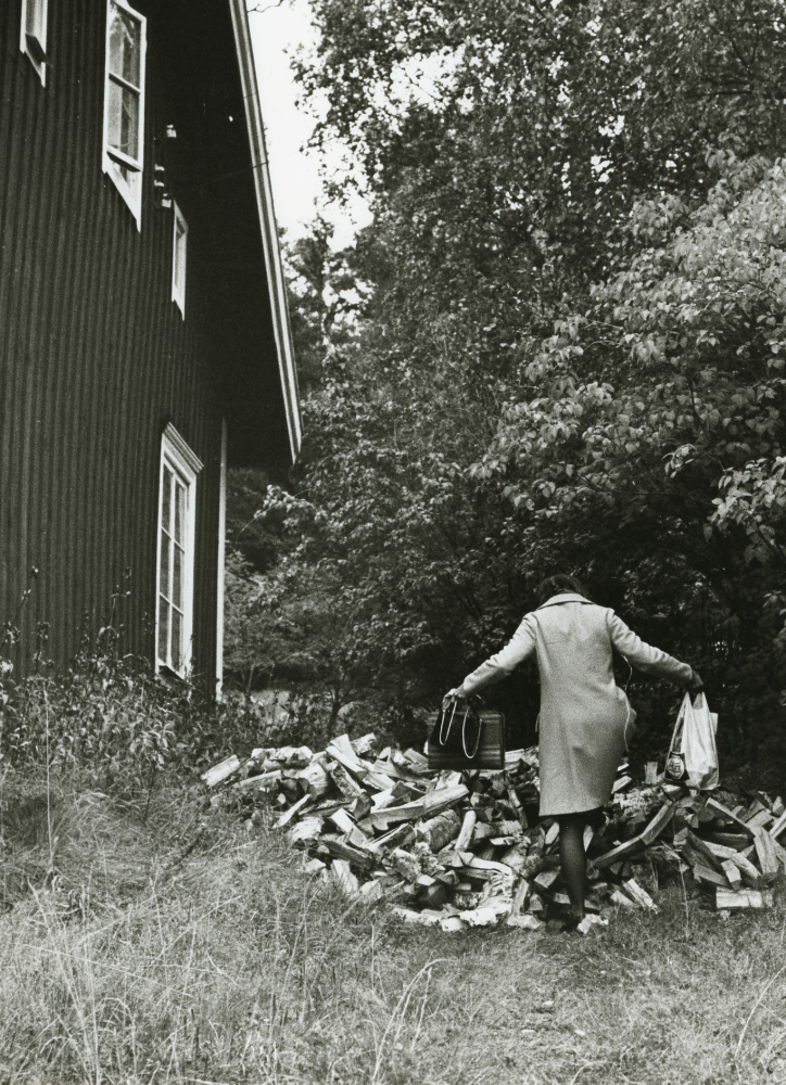 Två kubikmeter kapad björkved har levererats till en villa i gamla Haga. De boende måste klättra över den stora vedhögen som har lastats av direkt på gången som leder till huset. För kapad och kluven björkved fick de vid den här tiden betala 100 kr kubiken.